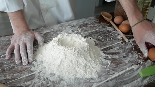 Chef Adds Egg to Flour on Table