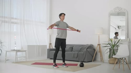 Man Working Out With Resistance Band in Living Room