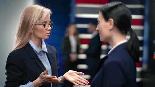 Two Business Woman Smiling Having Friendly Dialogue at Modern Office Interior Discussing Work