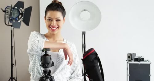 Photographer standing with digital camera in studio