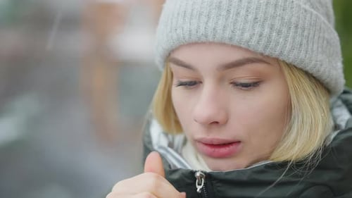 Woman Warming Her Hands in Winter Snow