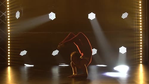 A Flexible Professional Female Athlete Performs Complex Acrobatic Elements of Rhythmic Gymnastics