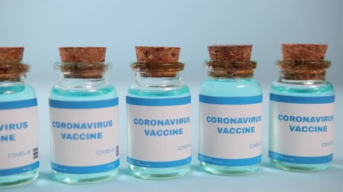 Vials of Coronavirus Vaccine on Light Blue Surface