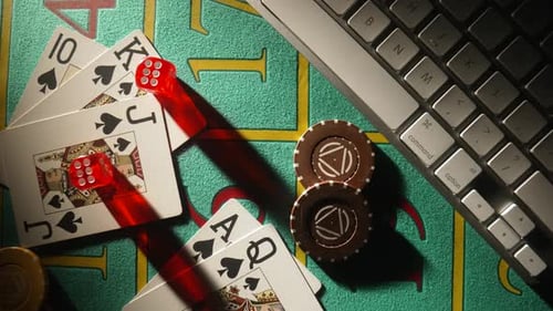 Top View of Gaming Table with Computer Keyboard Cards Dice and Casino Chips