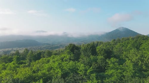 Flight Over the Mountains in the Morning. The Mountain Range on the Horizon Is Covered with Morning
