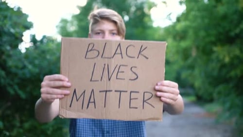Teen Holds Sign in Natural Outdoor Setting