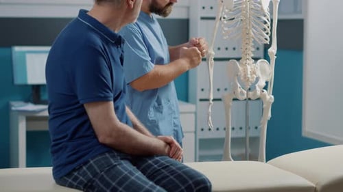Osteopathy Specialist Explaining Spinal Cord System on Human Skeleton
