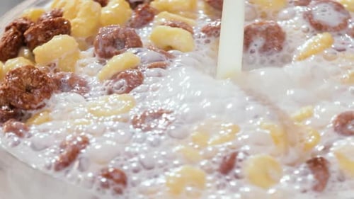 Milk being poured on sugar cereals for breakfast