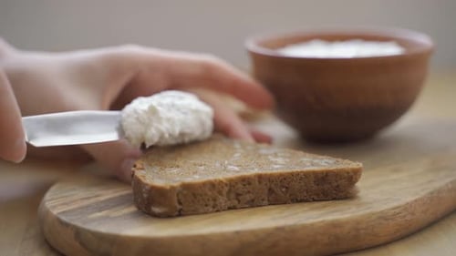Spreading Cream Cheese on a Slice of Bread