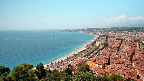 View of the cote d'Azur in Nice, France. Multiple resting on the beach people, buildings, blue water