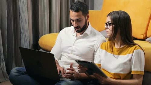 Woman and Man Using Laptop and Tablet Indoors