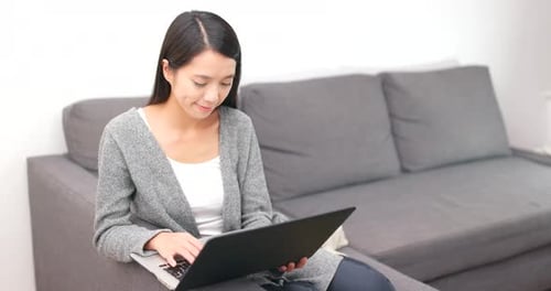 Woman Uses Laptop Computer on Couch at Home