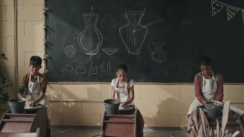 Children Making Pottery on Wheels in Class