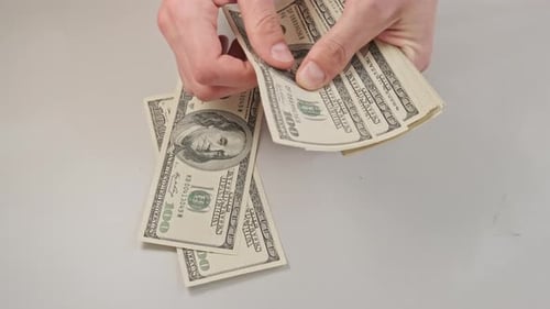 Hands Counting Stack of Hundred Dollar Bills