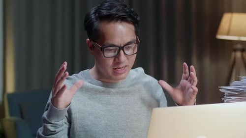 Close Up Of Asian Man Explaining Work While Having Video Call On Laptop At Home