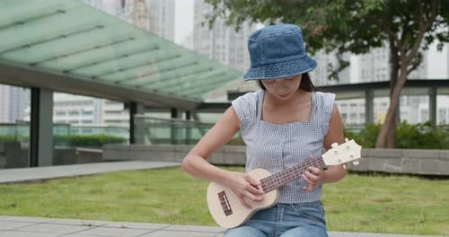 Woman playing ukulele at city