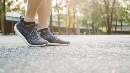 Legs Jumping in Athletic Shoes at Sunset