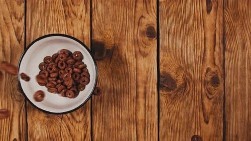 Pouring Cereal into Bowl on Wooden Table