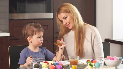 Young Woman with Her Adorable Little Son Making Handmade Decorations for Easter Holiday