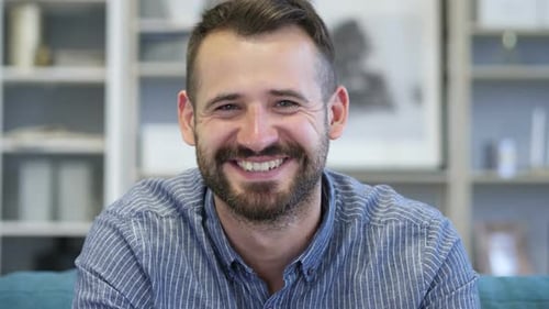 Smiling Man Waves and Speaks to Camera