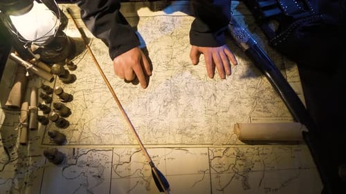 Hands Pointing on Map with Medieval Props