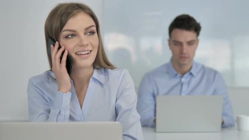Woman Talking on Phone at Office Desk