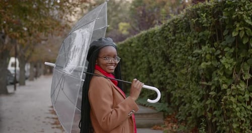 Black Girl with an Umbrella in the Middle of the Autumn Street