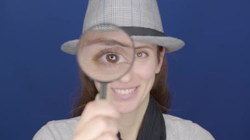 Drôle de fille regardant la loupe à la caméra