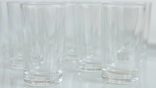 Close-up of shot glasses on white background 4K 2160p 30fps UltraHD tilting footage - Transparent s