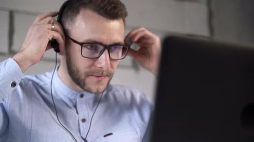 Call center worker puts on headphones and starts working with clients