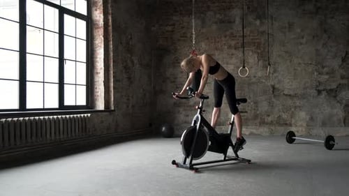 Woman working out on exercise bike at the gym. Female exercising on bicycle. Fitness woman working