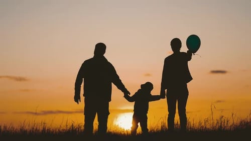 Family Holding Hands at Colorful Sunrise
