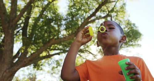 Young boy blowing bubbles through bubble wand