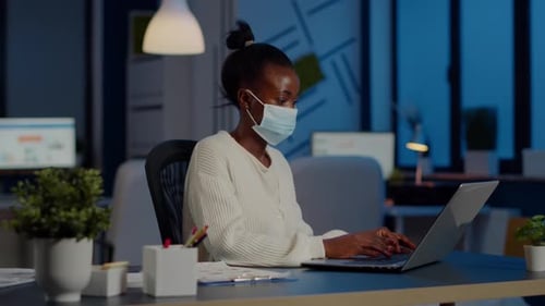 Employé africain avec masque de protection travaillant sur un ordinateur portable