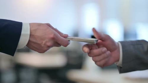 Close Up of Hand of Businessmen Giving Dollar To Another Person