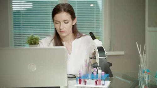 Femme médecin en laboratoire avec microscope