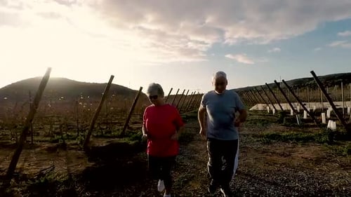Mature Couple Runs Together in Rural Setting at Sunrise