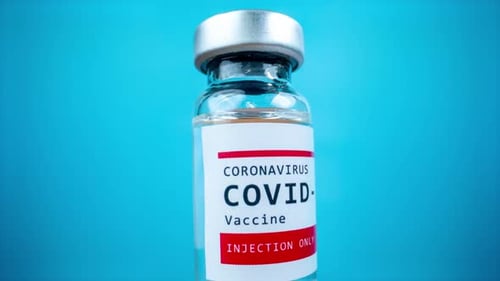 Frasco de vidrio de la vacuna contra el Covid19 sobre fondo azul