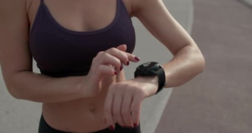 Fit Woman Scrolling on Smartwatch Outdoors