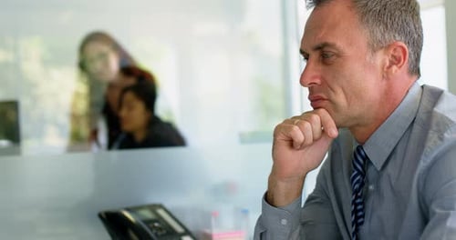 Gray-Haired Man Thinking in Modern Office Environment