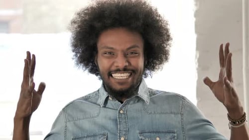 Man Cheers with Joyful Expression in Home Setting