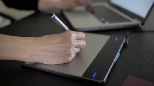 Person uses computer and drawing tablet