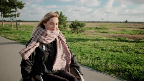 Smiling Handicapped Woman in Wheelchair on Enjoyable Outdoor Walk