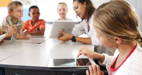Teacher teaching kid on digital tablet in library