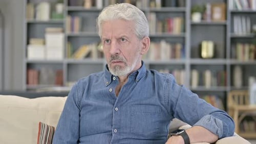 Ungeduldiger wartender alter Mann schaut auf Smartwatch