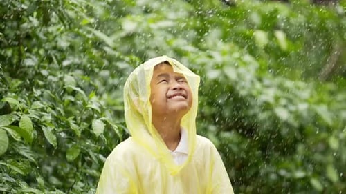 Child in Raincoat Smiling in the Rain