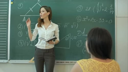 Teacher Explains Math Equations at the Chalkboard
