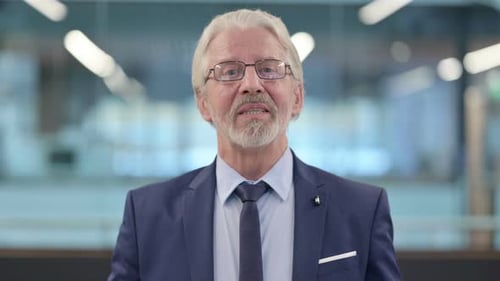 Senior Man Speaking Positively in Office Setting