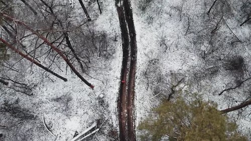 Frau läuft im verschneiten Winterpark Top-Luftbildtraining für Marathonwettbewerb