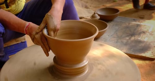 Des mains habiles de potier façonnent l'argile sur Potter Wheel et sculptent un pot en argile. Shipagramme